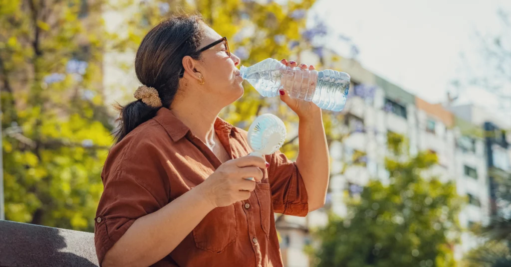 Mulher bebendo água durante onda de calor extremo