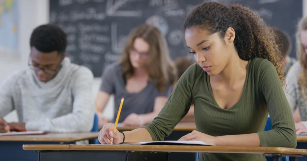 Uma estudante de pele negra em uma sala de aula aprendendo a como estudar para o vestibular na área da saúde